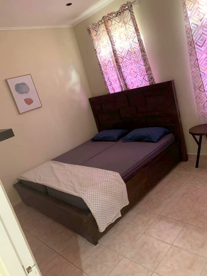 A bedroom with a double bed and patterned curtains
